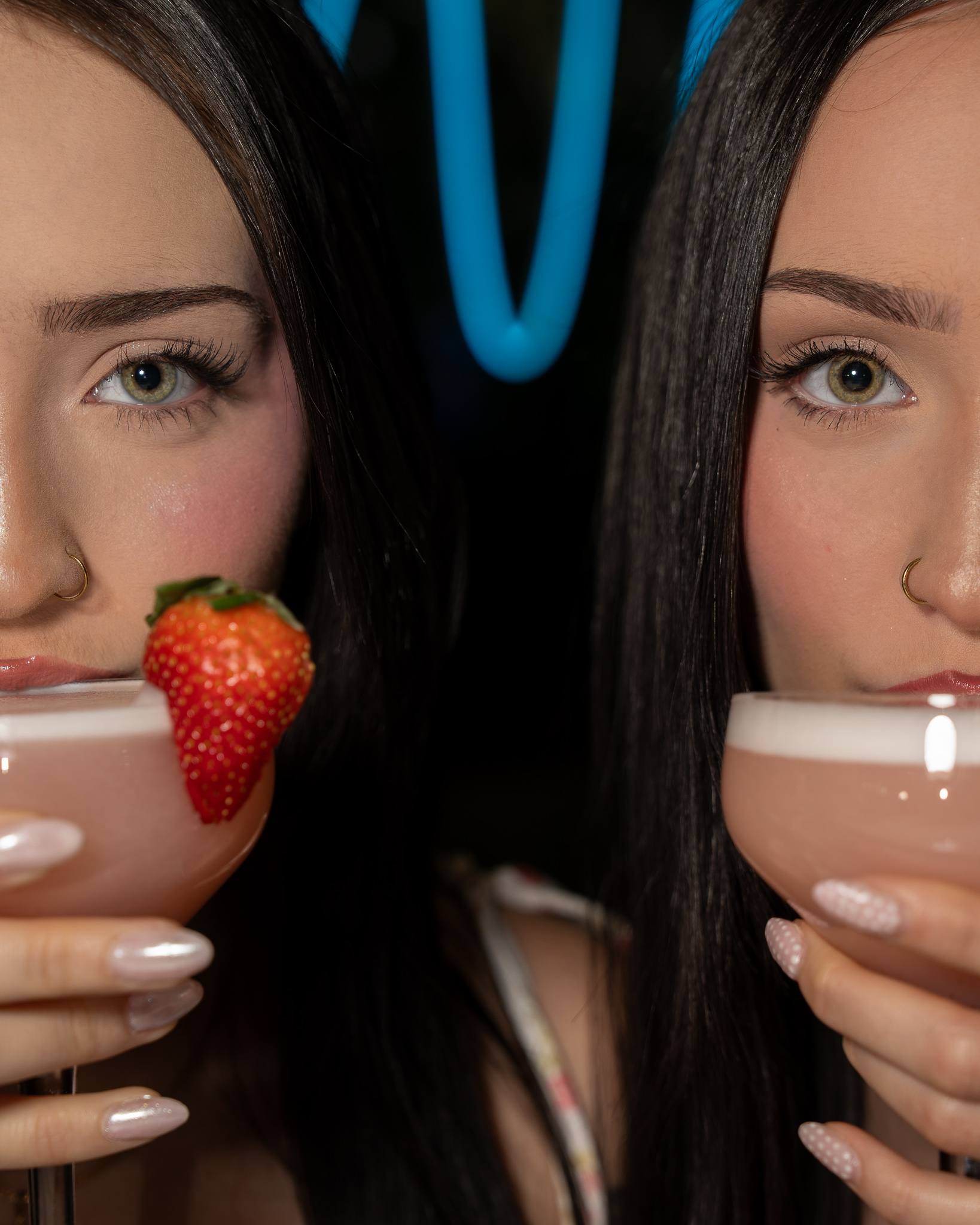 Two guests hold pink cocktails in coupe glasses close to the camera.