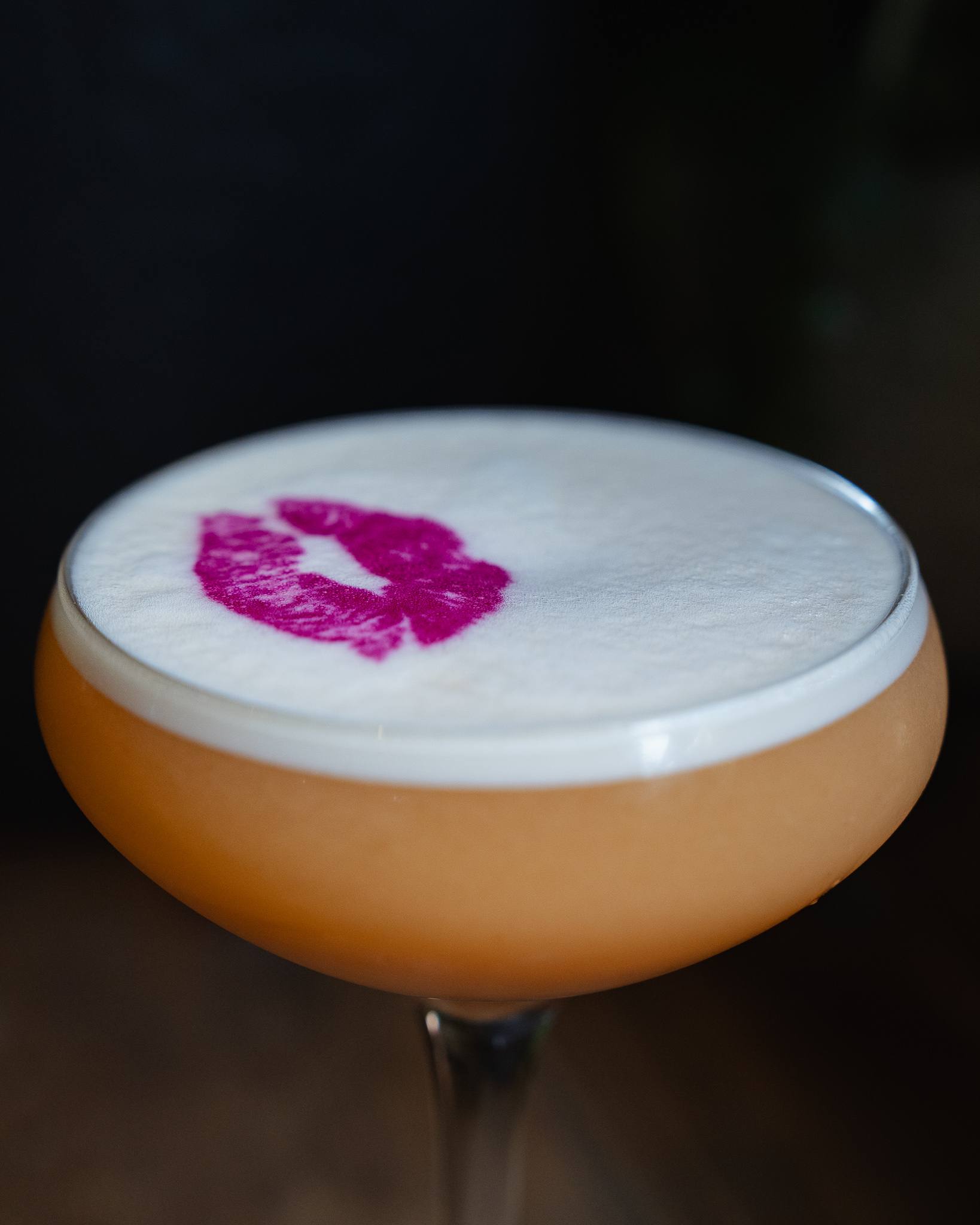 Close-up of a lipstick-kiss print on cocktail foam.